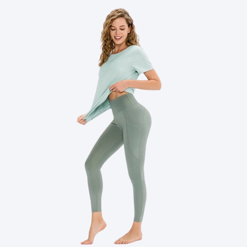 Femme portant un legging de yoga vert avec poches, taille haute et coupe ajustée