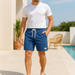 Homme portant un short bleu gaufré près d’une piscine – tenue estivale légère et stylée