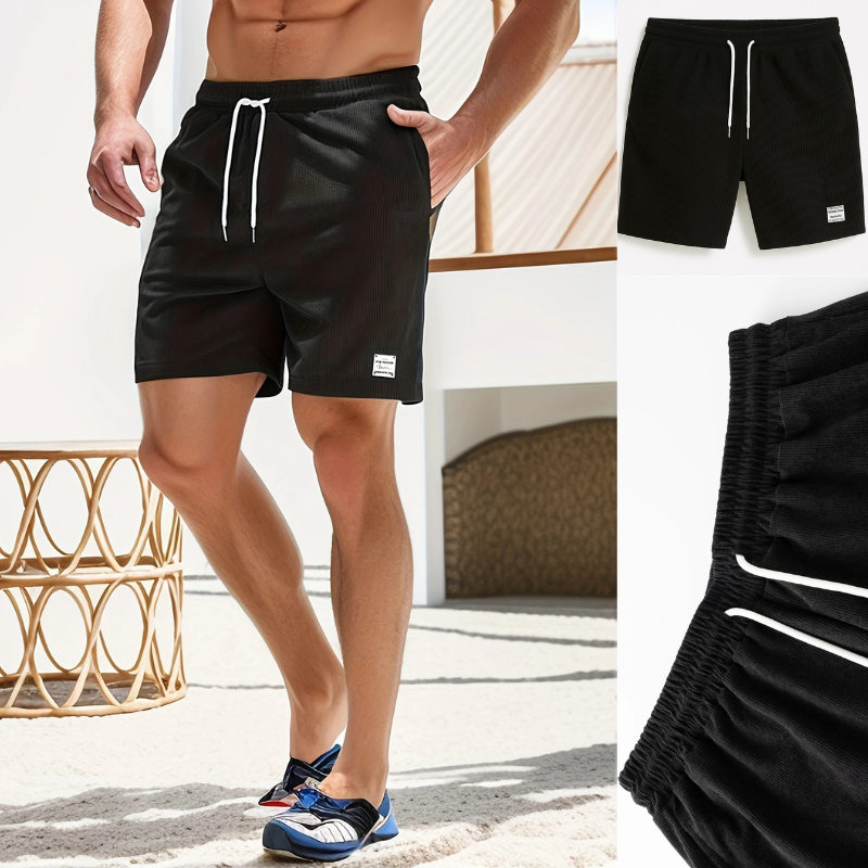 Short noir homme gaufré porté à la plage – look été stylé et tissu technique confortable