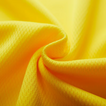 Gros plan sur la matière polyester respirante du t-shirt sport jaune, texture technique ultra légère et douce, idéale pour le running et le fitness