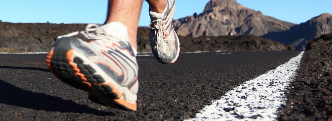 Coureur en pleine accélération sur route pour améliorer sa VMA et sa vitesse maximale aérobie en course à pied.