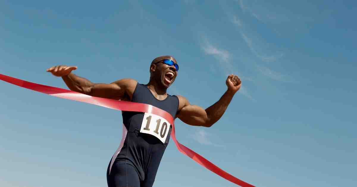 Athlète en course à pied franchissant la ligne d’arrivée, illustrant la progression et la performance en running.