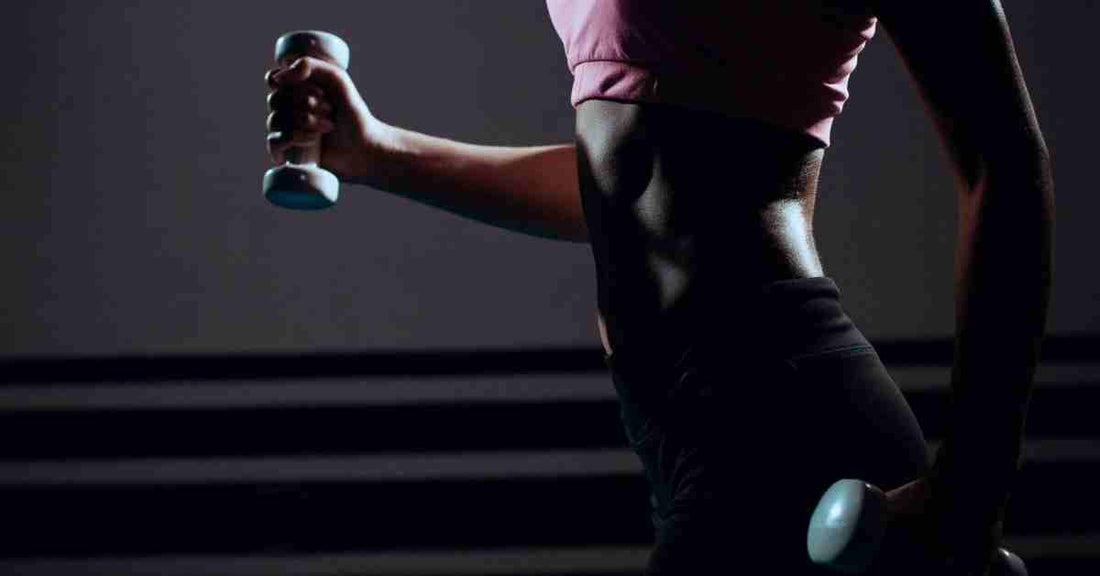 Femme en tenue fitness avec haltères – équipement idéal pour débuter le fitness en salle