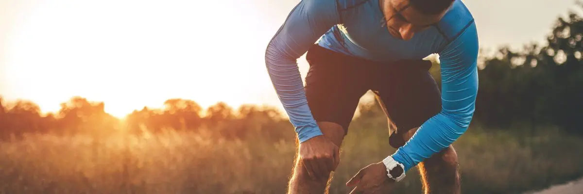Coureur en tenue de sport récupérant après une course de 10 km au lever du soleil, récupération running 2025