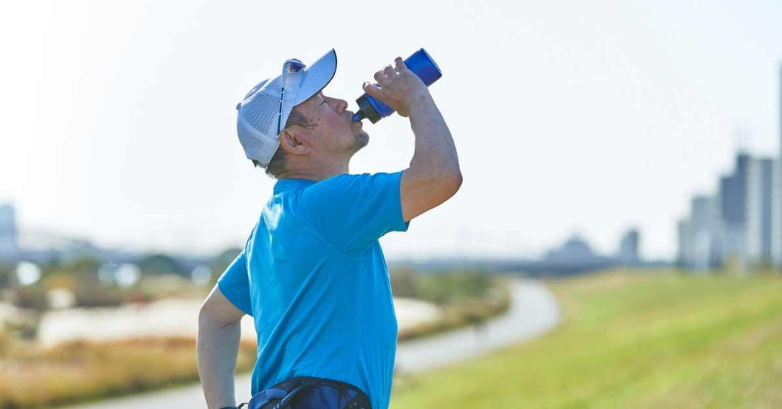 Coureur buvant de l’eau pendant un entraînement running sous forte chaleur en extérieur