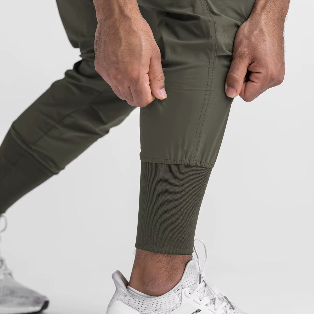 Jogger running homme kaki olive en nylon & spandex stretch. Coupe ajustée avec bas élastiqué côtelé, cordon de serrage et poche cargo fonctionnelle. Conçu pour la mobilité, le fitness et l’entraînement outdoor.
