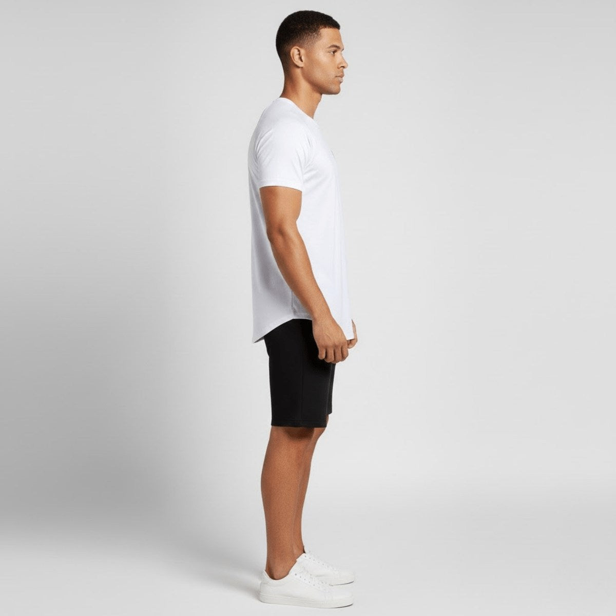 T-shirt de sport homme blanc porté, vue de profil, coupe ajustée et longueur confortable