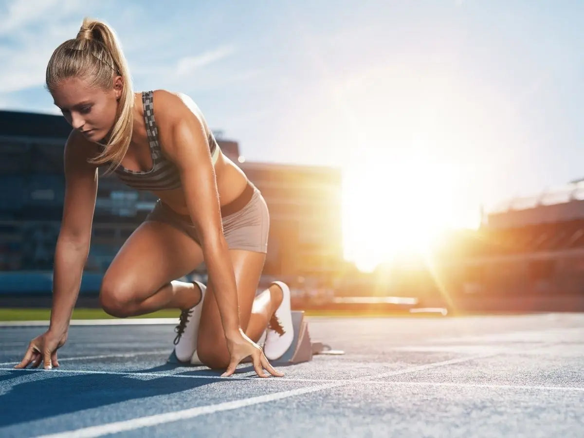 Coureuse en départ de sprint sur piste pour travailler sa VMA et améliorer sa vitesse maximale aérobie.