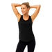 Femme souriante en débardeur noir, bras levés, posture dynamique et tissu respirant