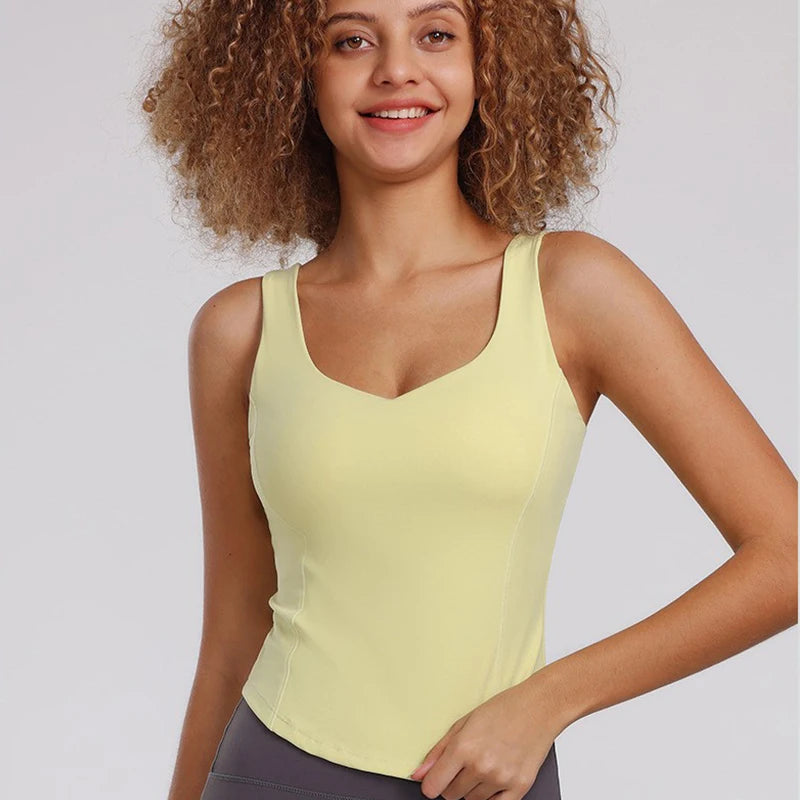 Débardeur sport femme jaune vitalité, effet gainant et tissu respirant avec brassière intégrée, idéal fitness, running et yoga.