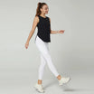 Débardeur de sport femme noir respirant en mouvement, associé à un legging blanc, idéal pour la marche sportive, le fitness et le running
