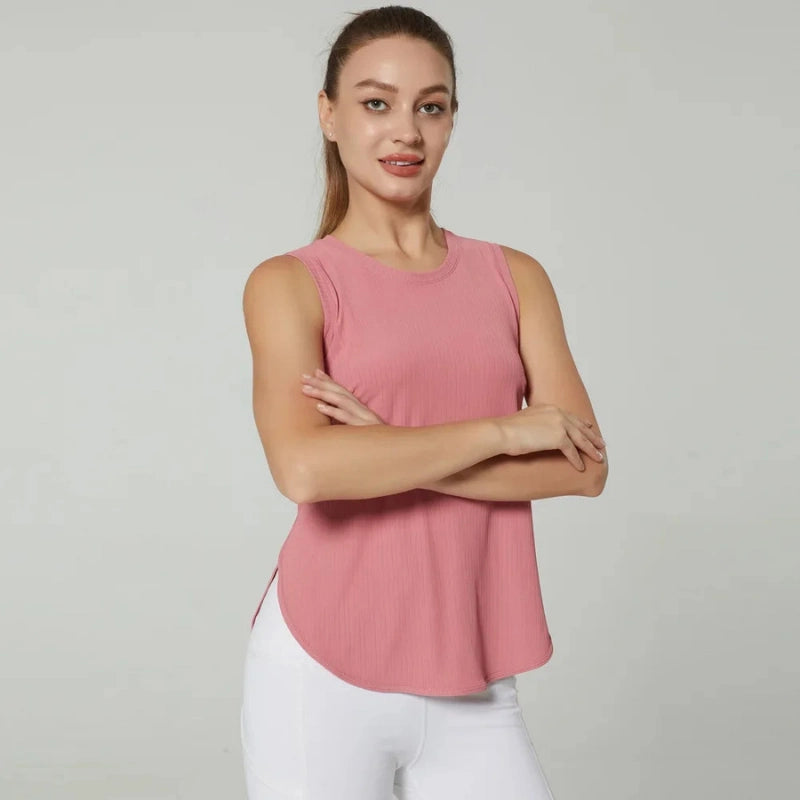 Débardeur de sport femme rose respirant, vue de face avec bras croisés, idéal pour le fitness, le yoga et les entraînements quotidiens