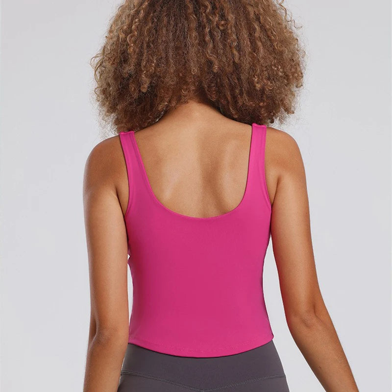 Débardeur sport femme rose énergie, dos dégagé offrant une liberté de mouvement optimale pour fitness et yoga.
