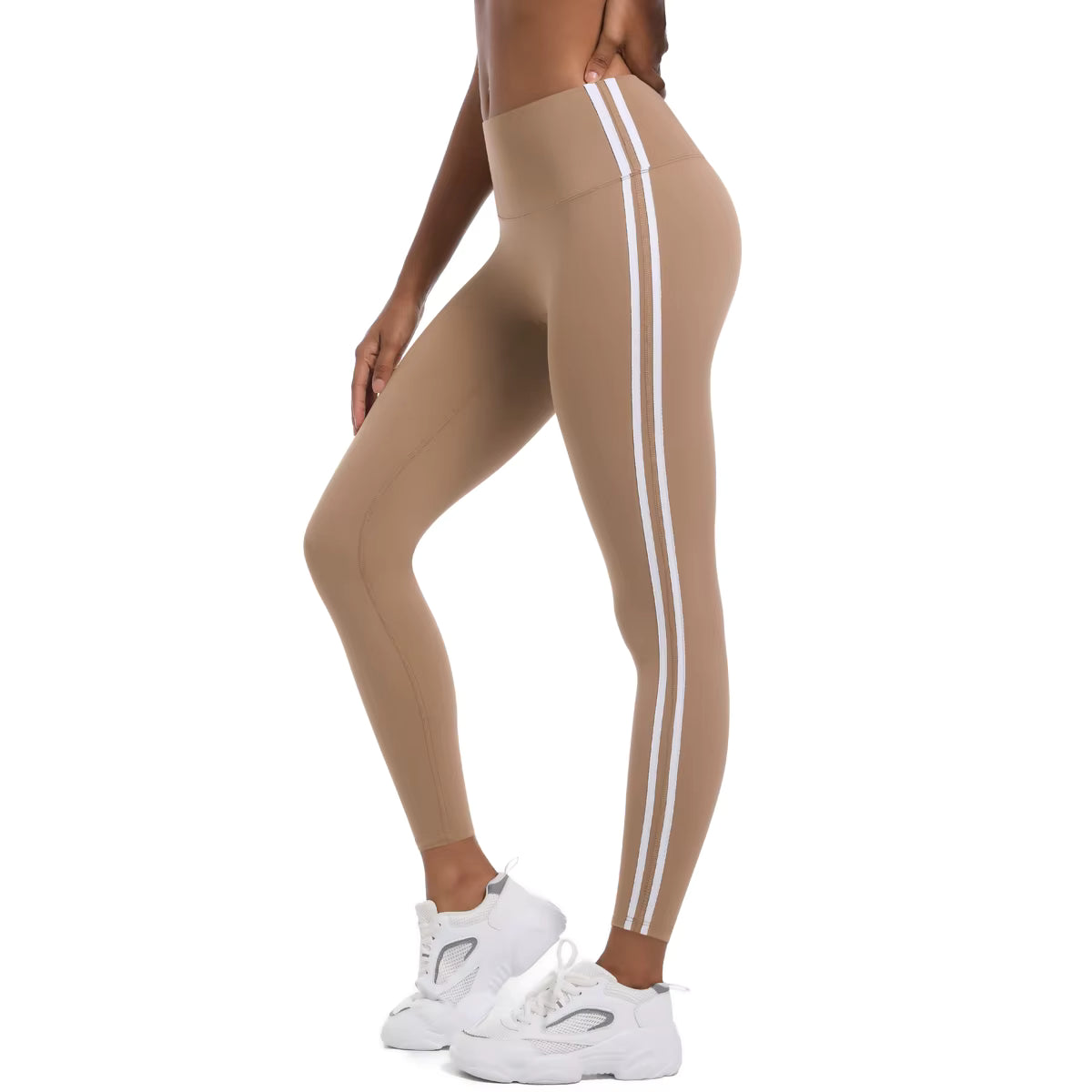Legging de sport femme beige sable porté en mouvement avec bandes latérales et coupe ajustée

