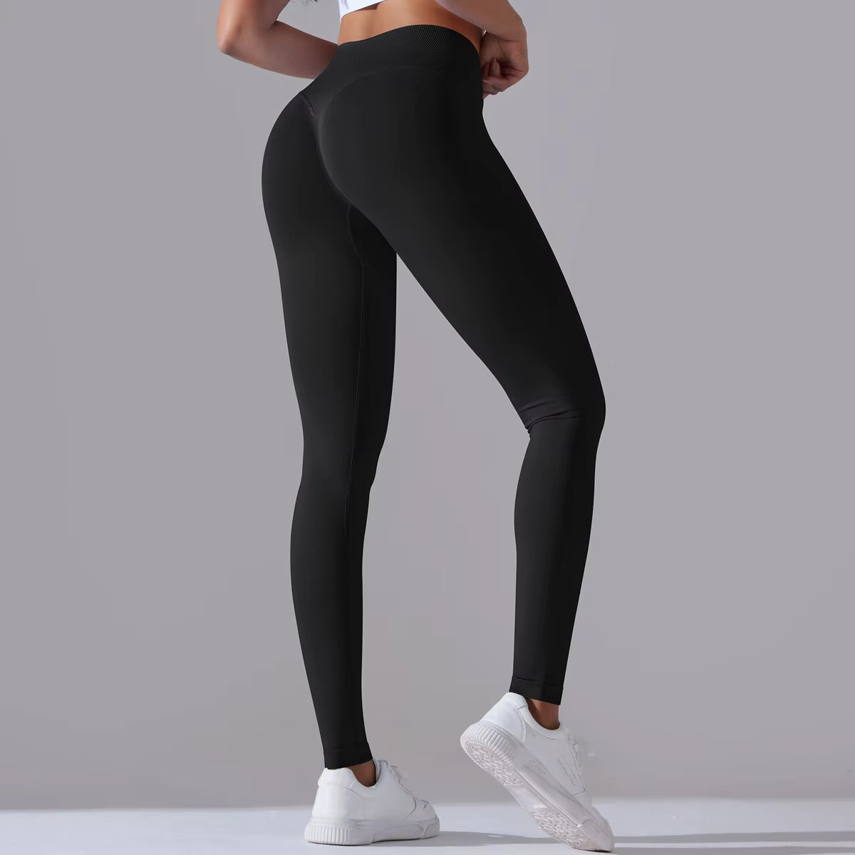 Vue arrière dynamique du legging de sport femme noir avec taille haute gainante et effet galbant
