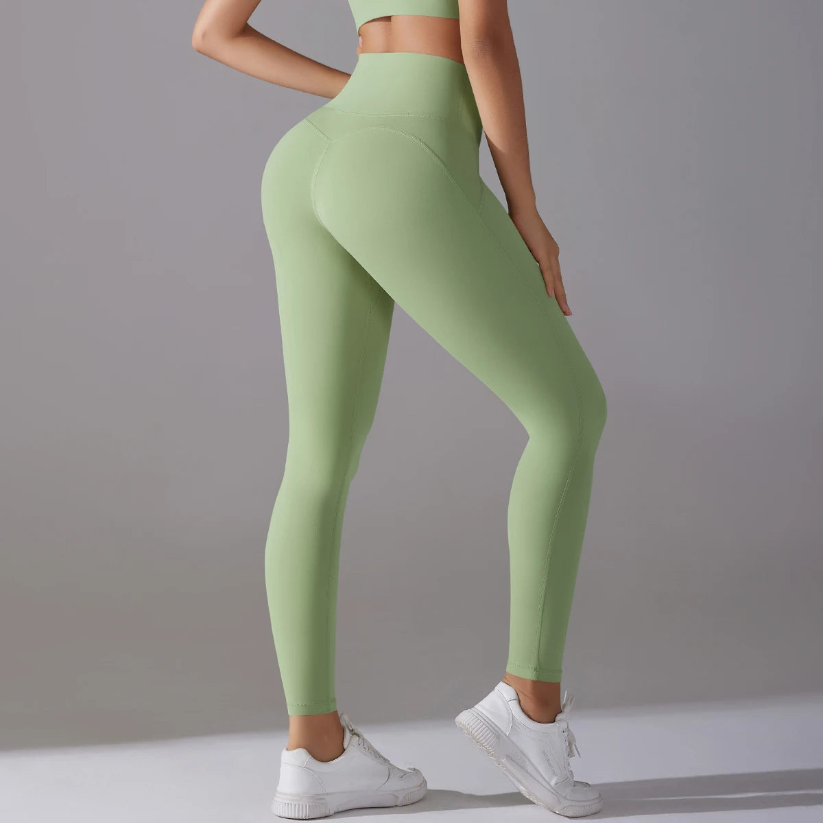 Legging de sport femme vert clair vue arrière avec taille haute et maintien galbant
