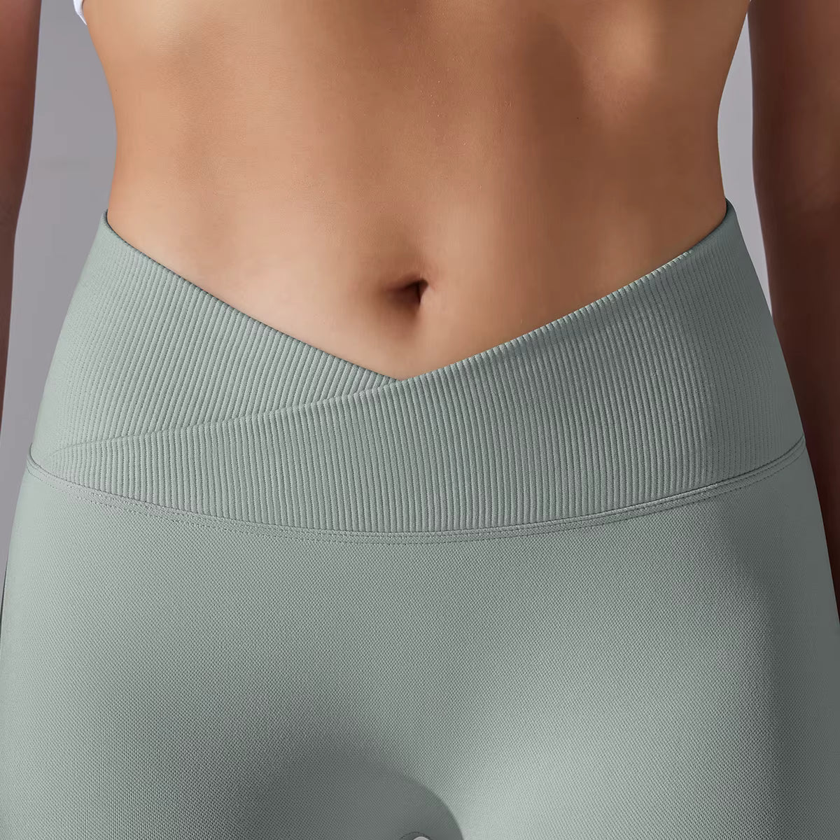 Détail de la taille haute du legging de sport femme vert sauge clair avec ceinture gainante
