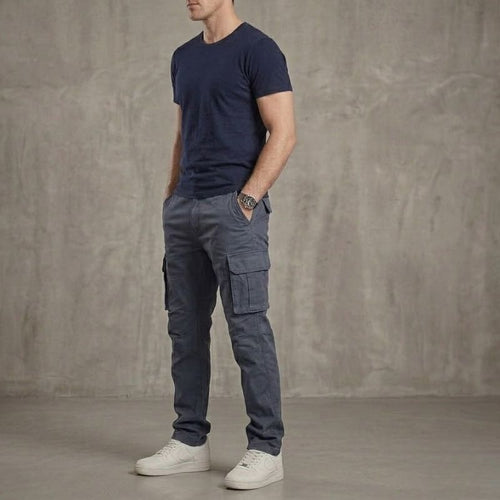 Pantalon cargo homme bleu en coton style tactique avec poches latérales porté avec t-shirt, pantalon confortable pour randonnée et usage quotidien