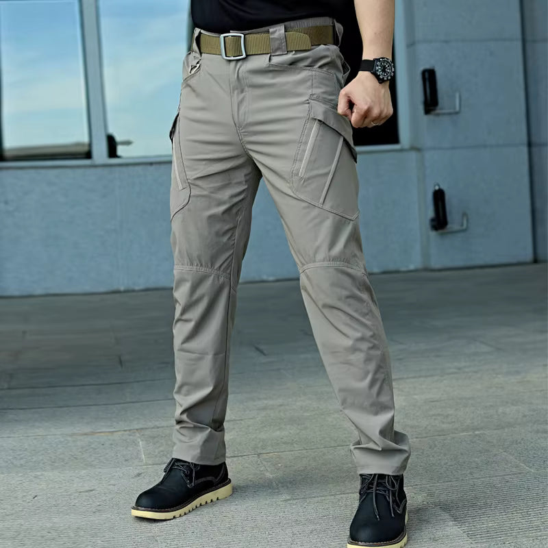 Pantalon cargo tactique homme beige porté en extérieur, pantalon multi poches confortable pour outdoor et usage quotidien