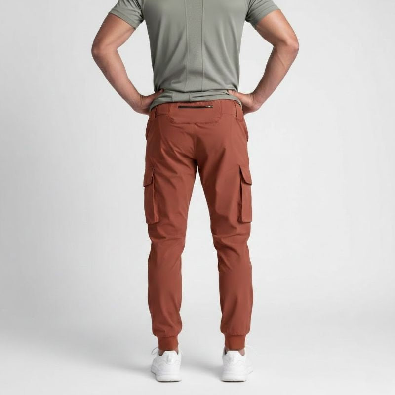 Jogger cargo homme terracotta intense en tissu stretch nylon et spandex, vue arrière avec poche zippée sécurisée et bas resserré.
