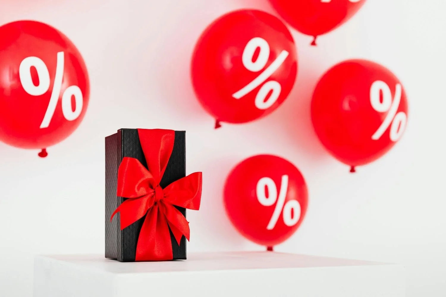 Cadeau avec ruban rouge et ballons de réduction pour promotion spéciale