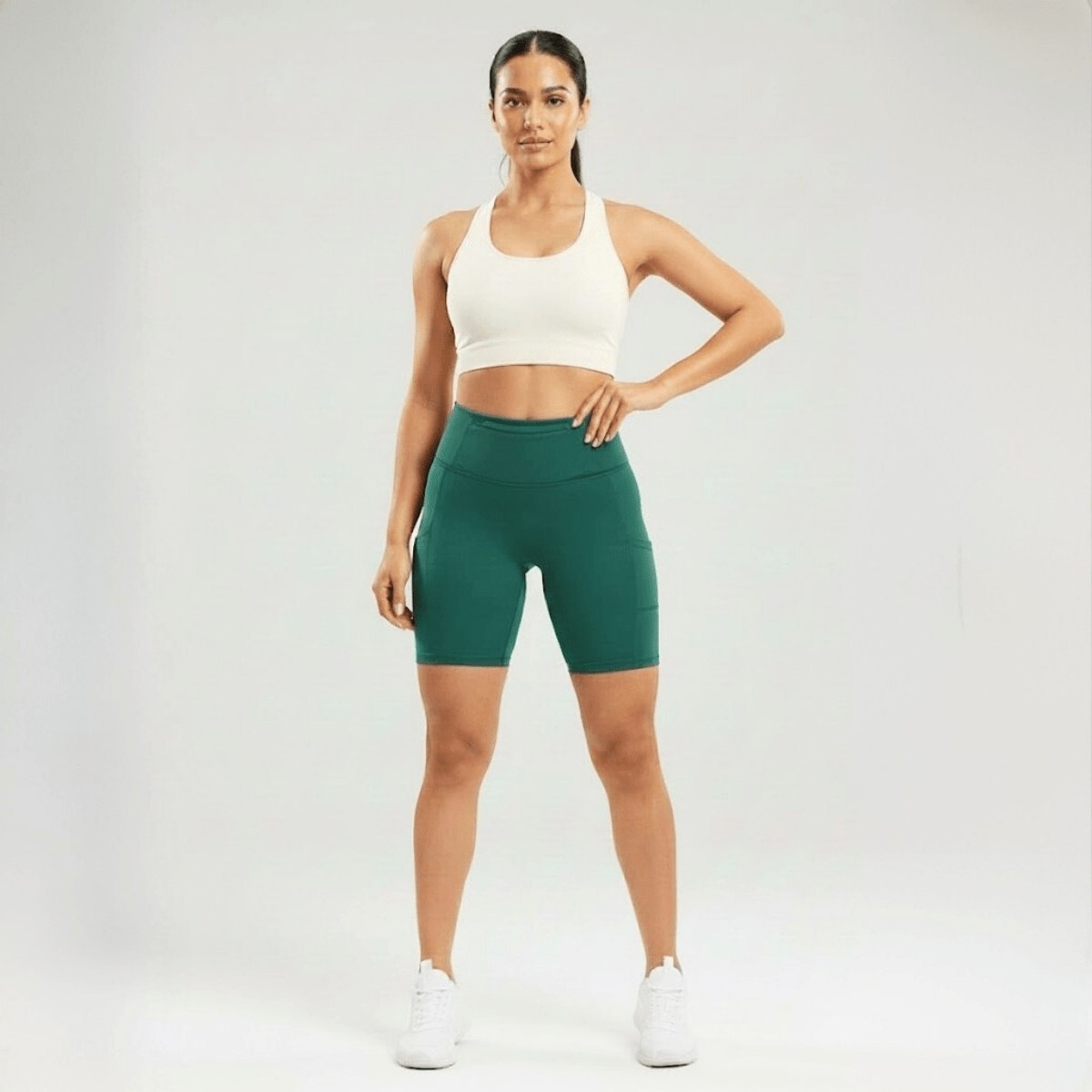 Short de compression femme vert taille haute avec poche latérale, vue face, maintien confortable pour fitness et training