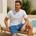 Homme en short bleu gaufré assis en terrasse près de la piscine – look d’été décontracté et stylé