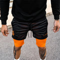 short-running-homme-2-en-1-noir-compression-orange-vue-face-decateamsports
