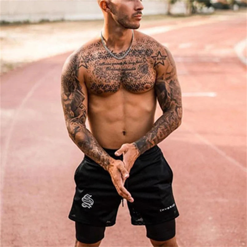 Short running homme noir 2 en 1 avec compression intégrée porté en extérieur sur piste d’athlétisme
