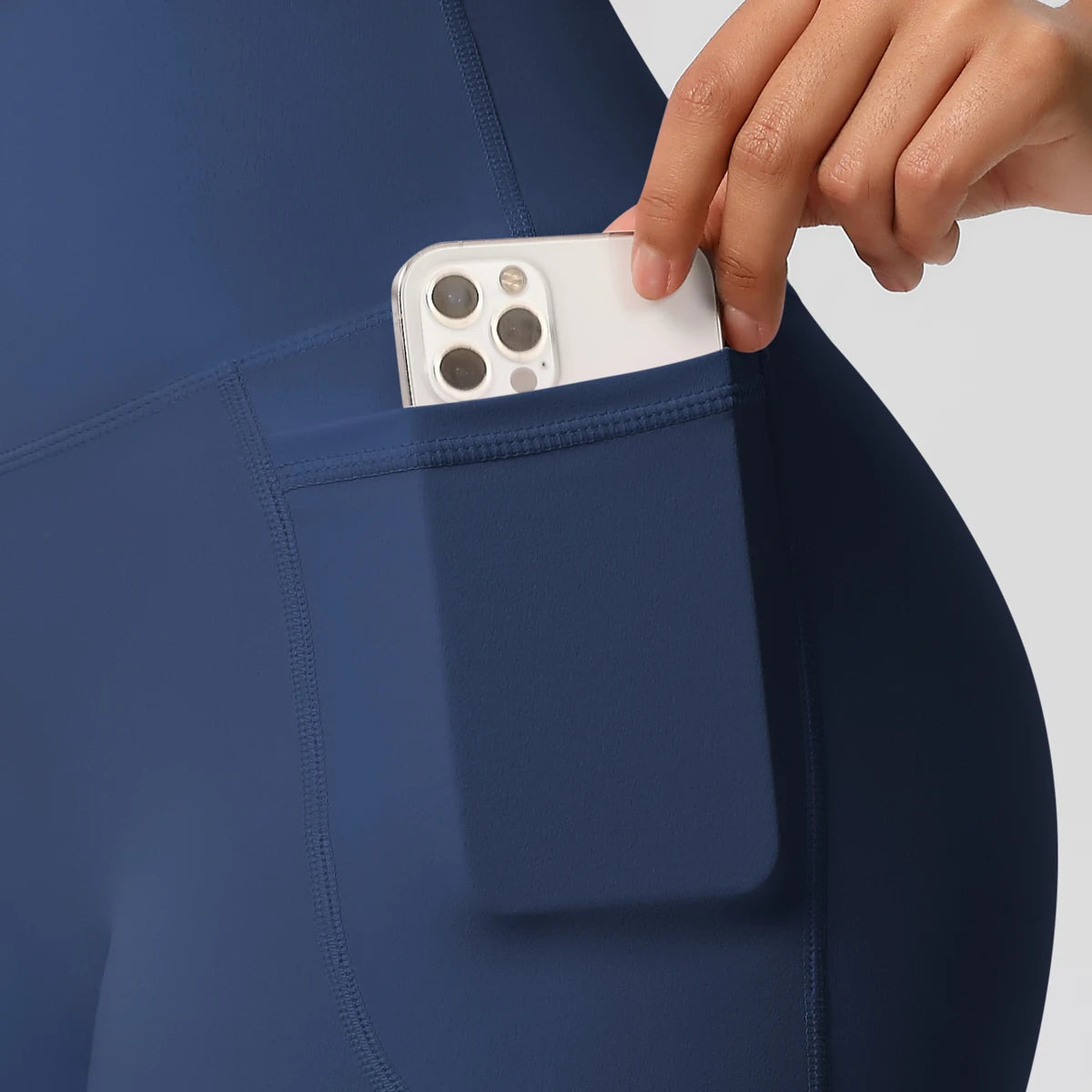 Détail de la poche latérale du short sport femme taille haute bleu, pratique pour téléphone pendant le sport.
