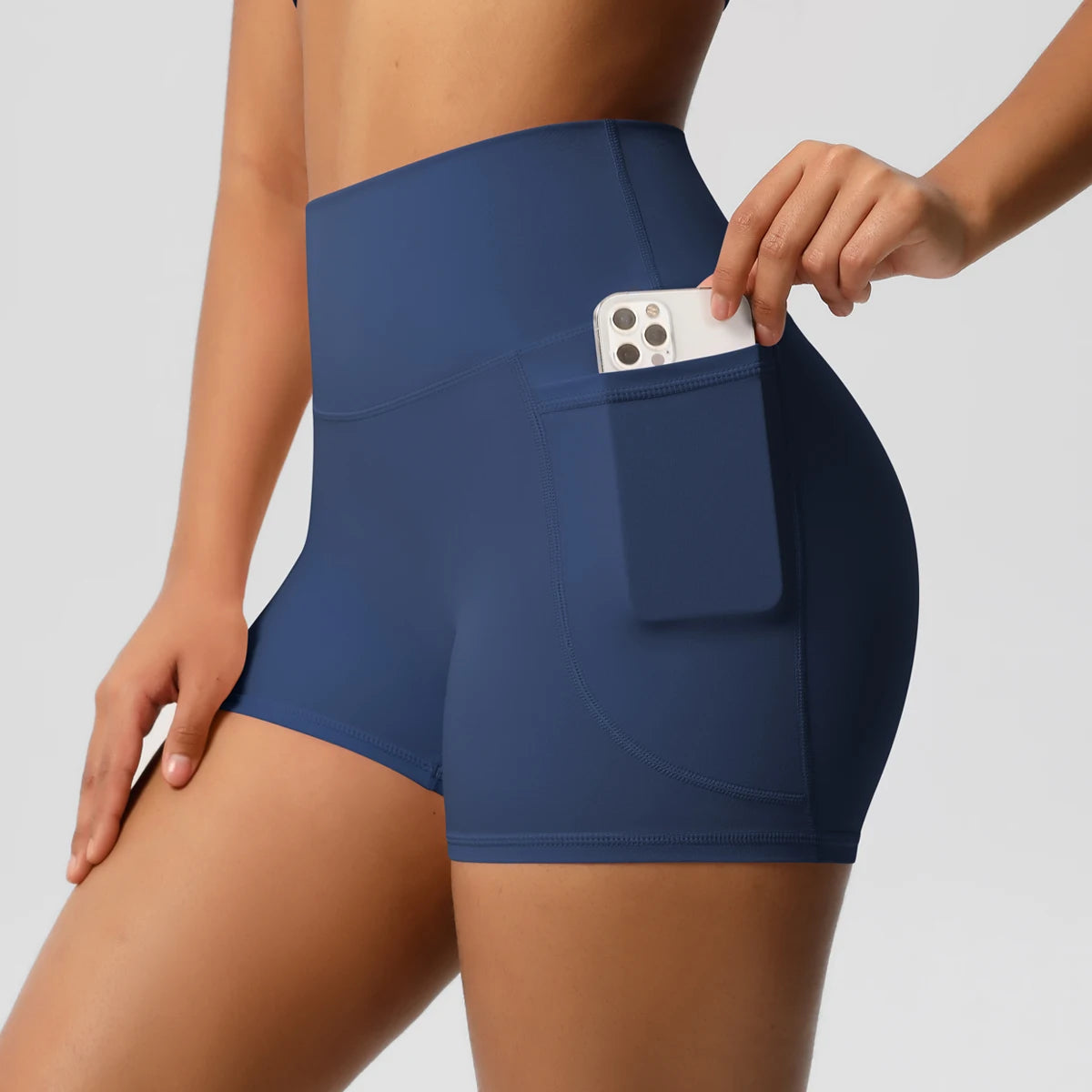 Short sport femme taille haute bleu avec poche, vue de face, confortable et extensible pour fitness et yoga.
