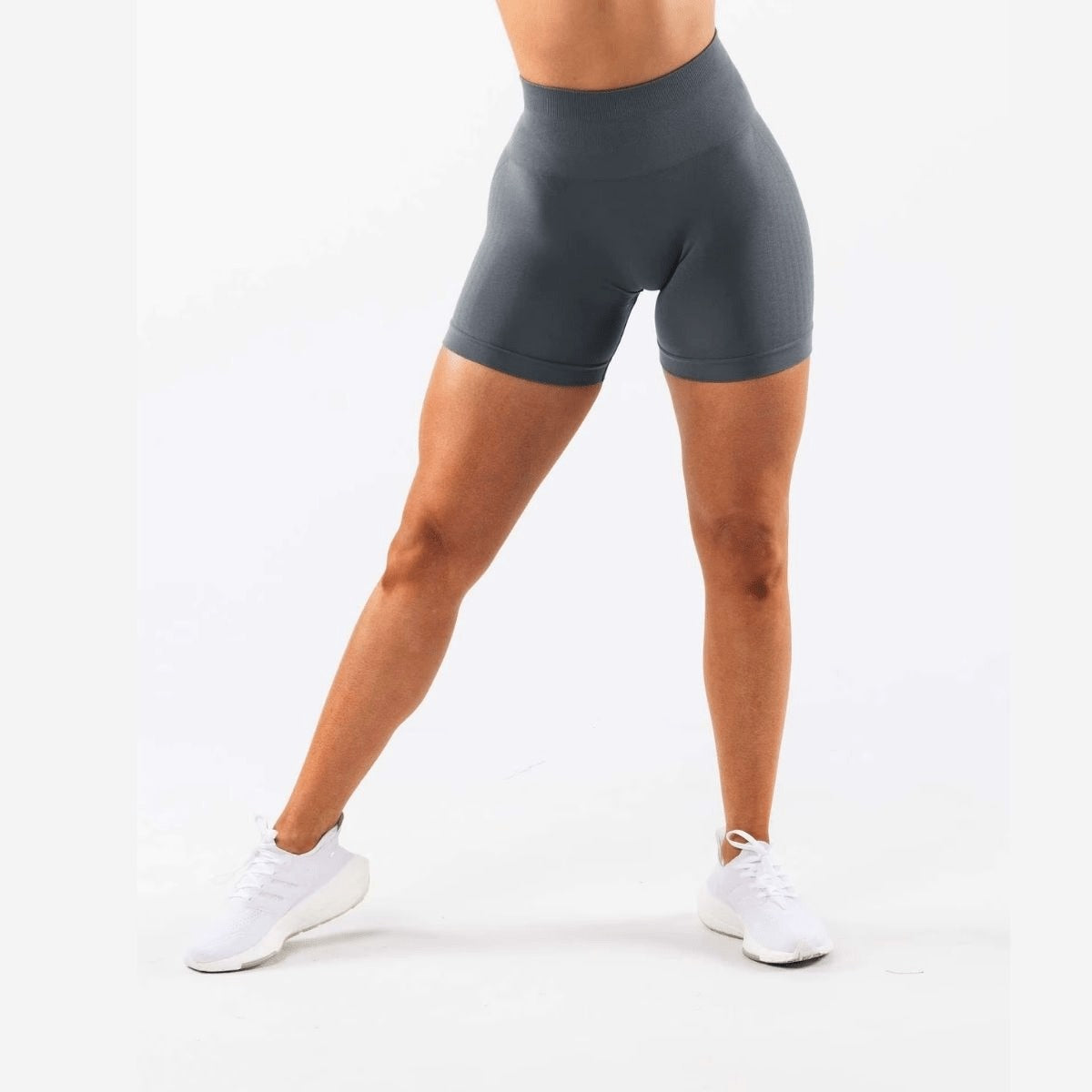 Short sport femme taille haute gris graphite porté en mouvement, idéal pour fitness, yoga et training.
