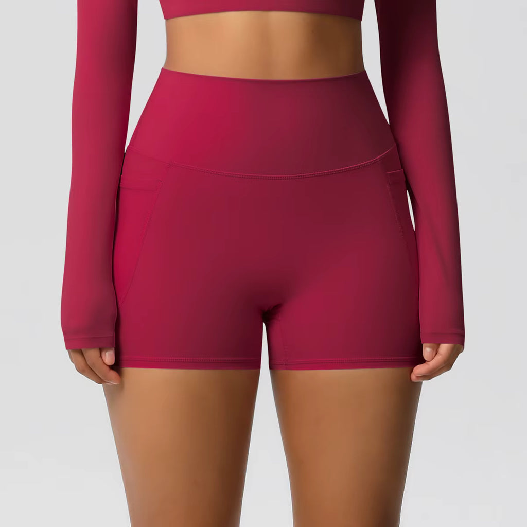 Short sport femme taille haute rouge, vue de face, tissu extensible et maintien optimal pour fitness et yoga.
