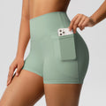 Détail de la poche latérale du short sport femme taille haute vert clair, pratique pour téléphone pendant le sport.
