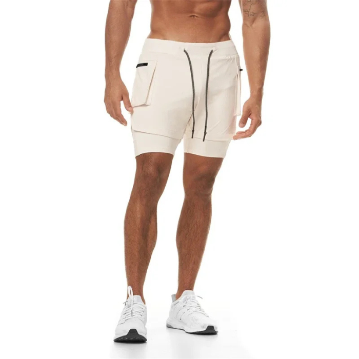 Short sport homme ECET blanc – porté de face avec grandes poches zippées, coupe ajustée et design technique.