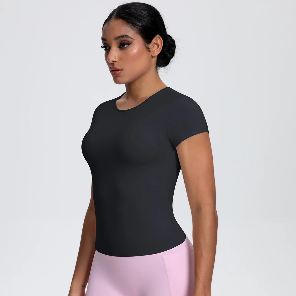 T-shirt de sport femme Carbon Shadow en vue de profil, coupe gainante, tissu respirant et extensible.