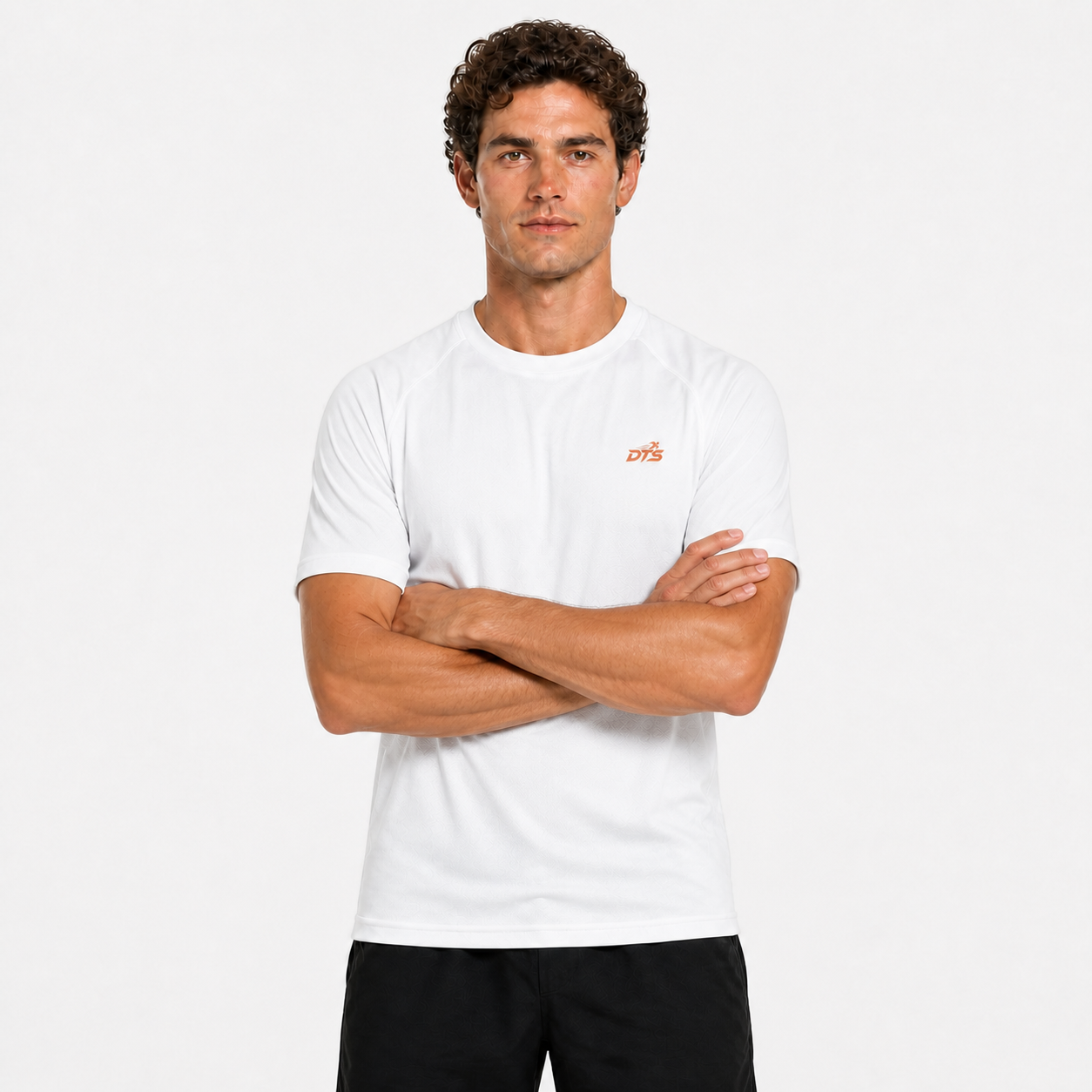 Homme portant le T-shirt de sport DTS blanc avec logo orange, bras croisés