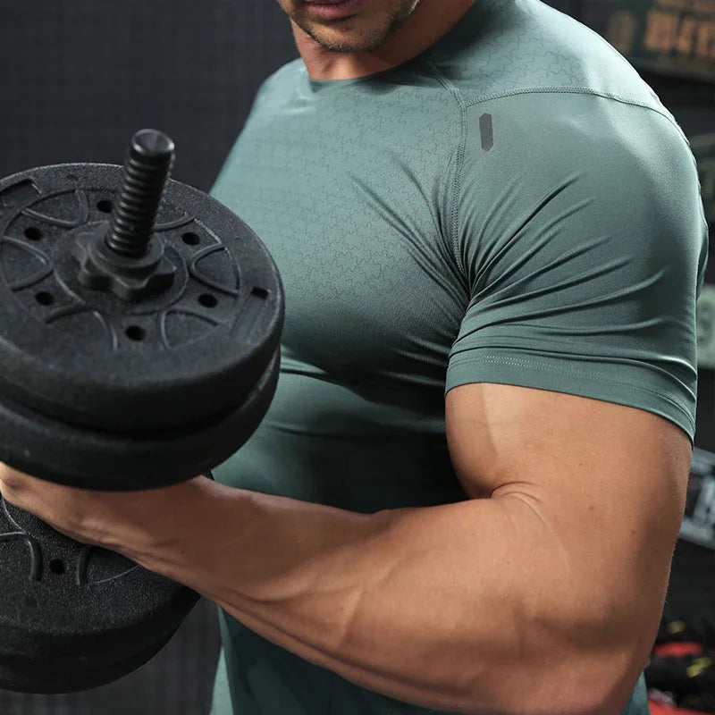 Détail du t-shirt de sport homme vert kaki montrant la respirabilité et l’élasticité du tissu
