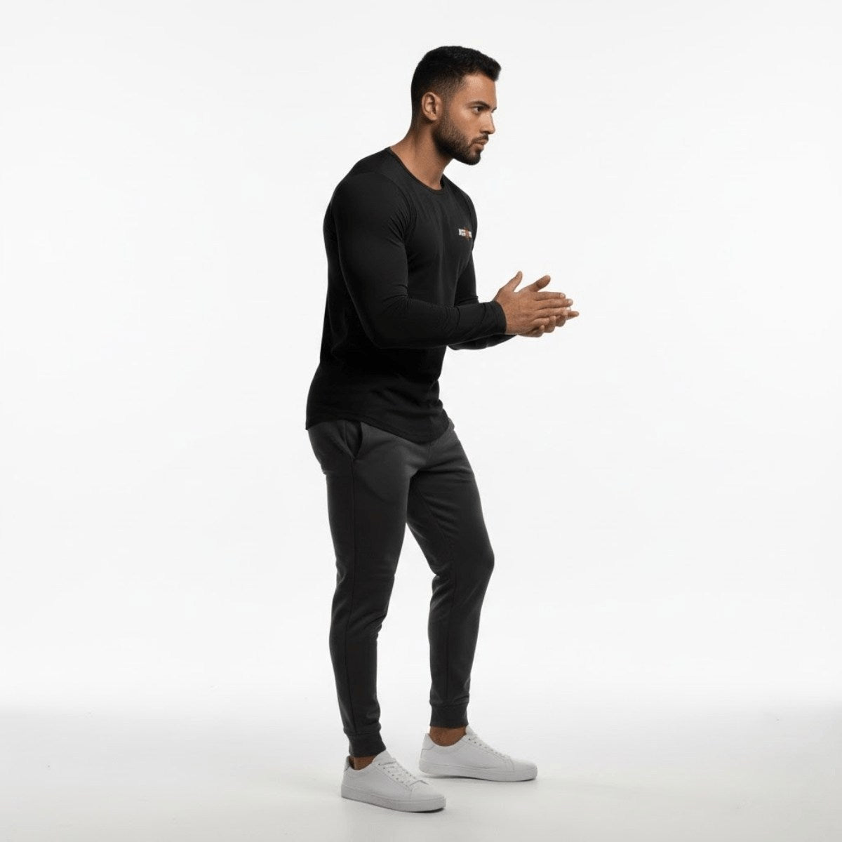 Homme en tenue de sport noire en position d’entraînement avec t-shirt ajusté
